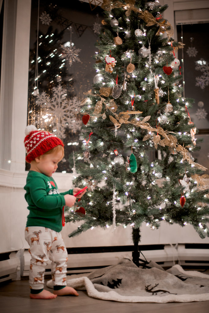 toddler looking at tree ornaments 