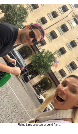Stephanie McAuley of Broad World and boyfriend ride scooters around Paris. 
