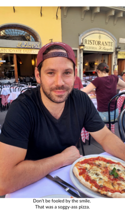 Broad World's boyfriend smiles and poses with pizza in Florence.