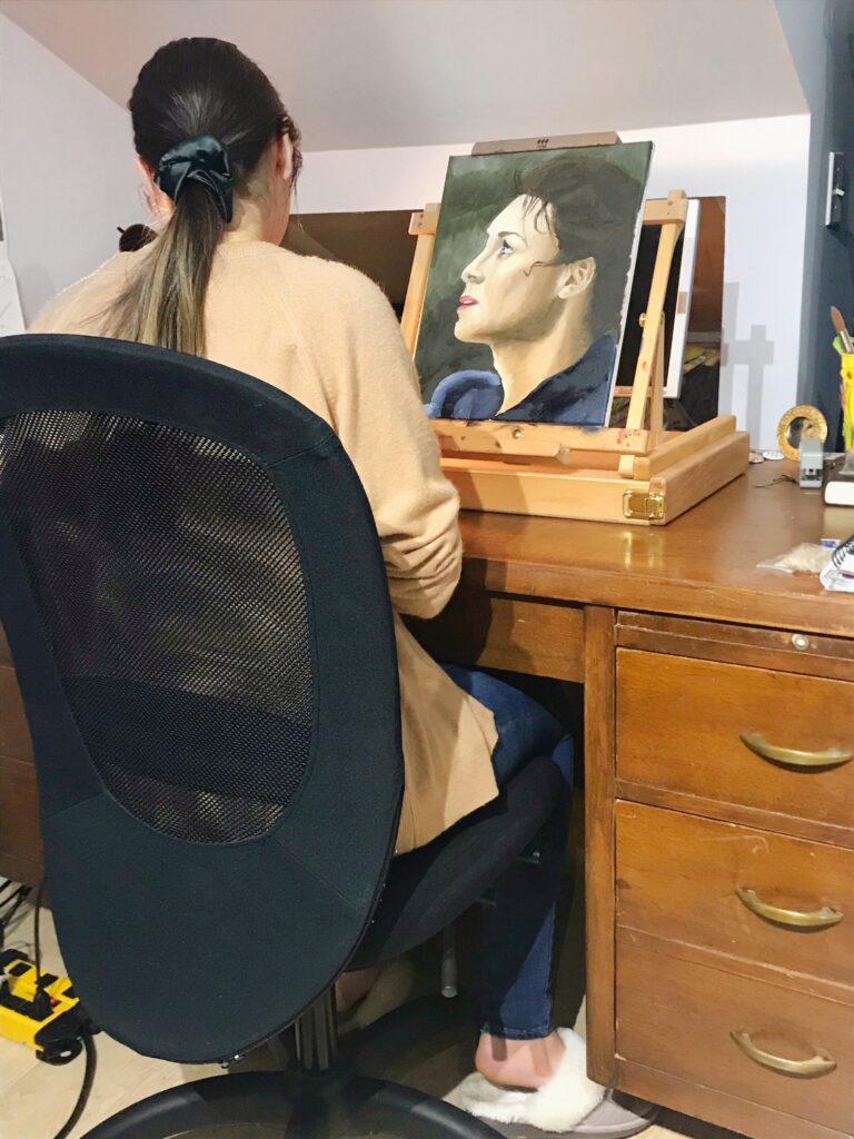 High school student, Mackenzie, paints a portrait with oil based paints.